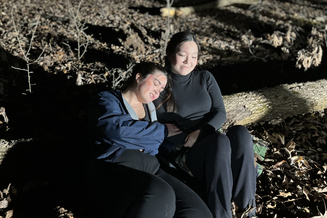 students sitting on log outside while filming hunger games scene