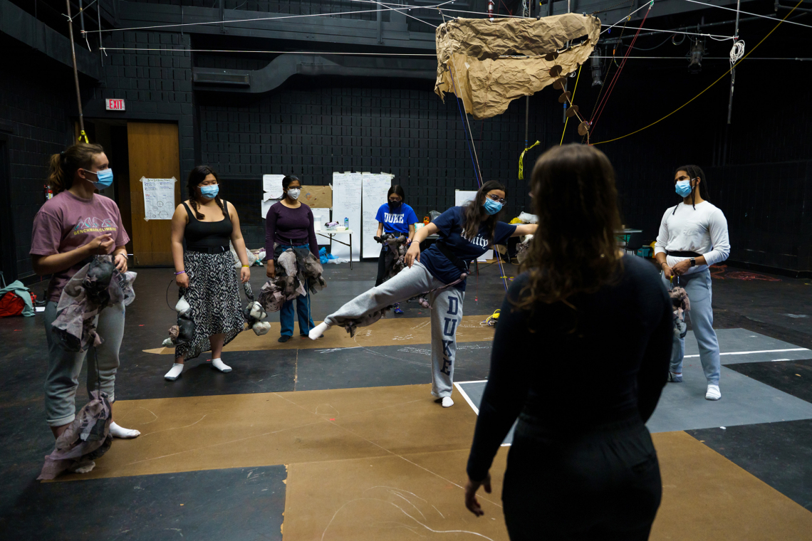 Student standing on one leg, interacting with the art build